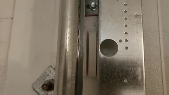 with a heavy duty double sided tape. fix the slimmer part on the shutter and the bigger part right next to it on the wall frame next to it